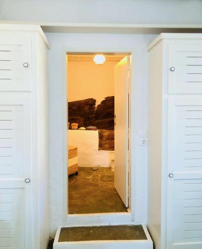 a room with a door leading to a bedroom at Thimari cottage in Andros in ayios Petros