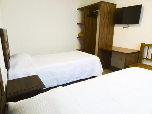a hotel room with two beds and a tv at Departamento Estrella de Mar in Puerto Vallarta