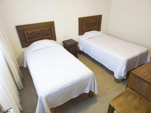 two beds in a room with white sheets at Departamento Estrella de Mar in Puerto Vallarta