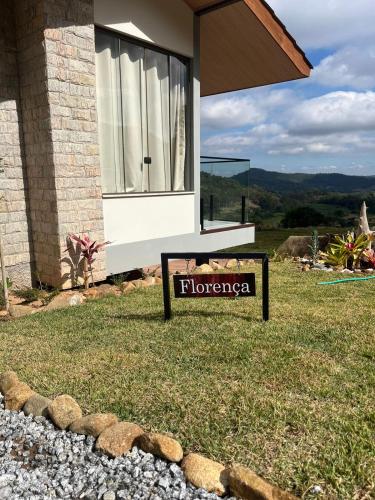 a sign in front of a house with a window at Pousada Refúgio Pietra Blu in Domingos Martins