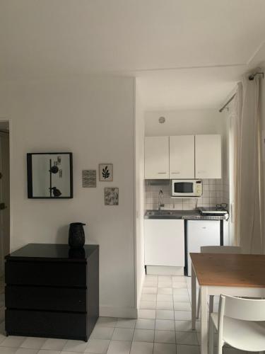 une cuisine avec des armoires blanches et une table à l'intérieur dans l'établissement Studio Gobelins, à Paris