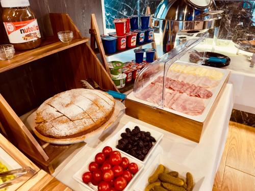 a buffet with a pie and tomatoes and other food at Hotel Olive in Vlorë