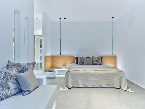 a bedroom with a bed and a couch at Blue Mare Villas in Naousa