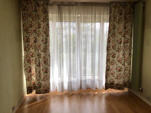 Cette chambre dispose d'une fenêtre avec des rideaux et de parquet. dans l'établissement Creteil 1, à Créteil