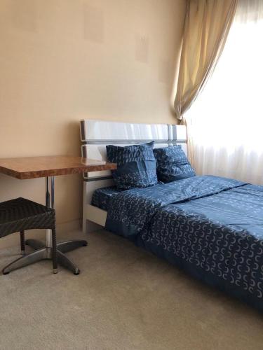 une chambre avec un lit et une table en bois dans l'établissement Creteil 1, à Créteil