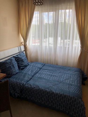 une chambre avec un lit bleu avec une fenêtre dans l'établissement Creteil 1, à Créteil