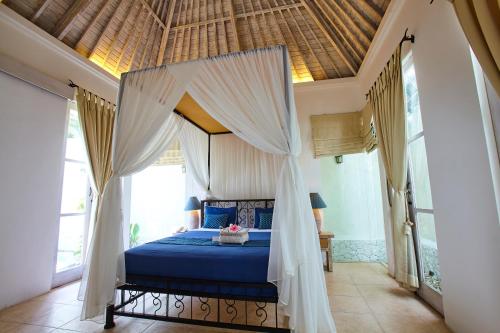 a bedroom with a bed with a canopy at Artemis Villa Hotel in Seminyak