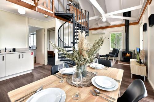a dining room and living room with a table and chairs at Bracken Ridge Vineyard in Rothbury