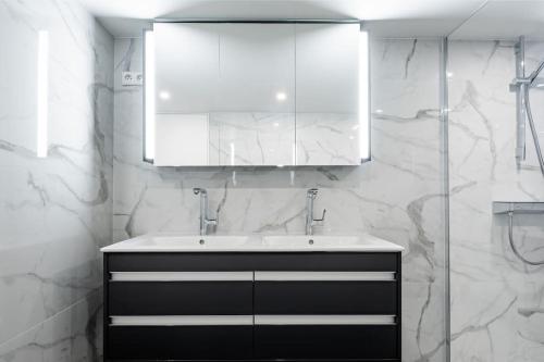 une salle de bain blanche avec un lavabo et un miroir dans l'établissement Modern loft - close to Eiffel Tower, à Paris