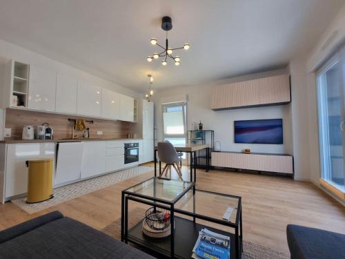 un salon avec une table et une cuisine dans l'établissement Cosy retreat with terrasse and parking, near Paris and Disney, 5min to train station, à Champigny-sur-Marne