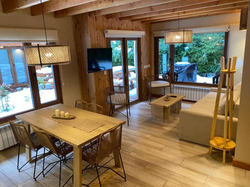a living room with a table and a couch at Remanso del Bosque - Los Alerces Cabin in Villa La Angostura