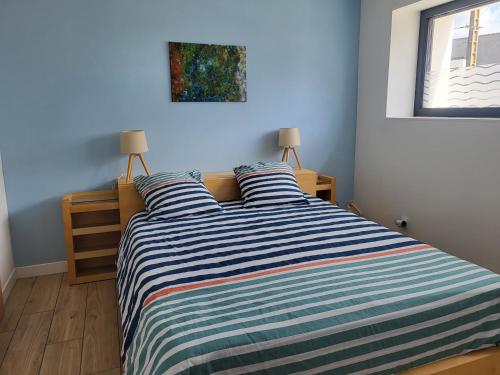 - une chambre avec un lit et une couette à rayures dans l'établissement Plein pied de la petite mer, à Riantec