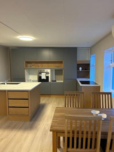 a kitchen with a table and chairs and a dining room at Sentralt hus med egen parkering in Egersund
