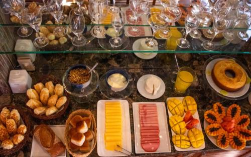 a display case filled with lots of different types of food at Casa Simone Pousada in Paraty