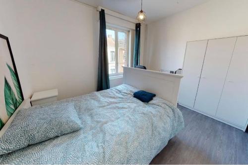 une chambre avec un lit et une grande fenêtre dans l'établissement Jungle House, à Roubaix