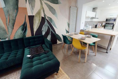 un salon avec un canapé vert et une table dans l'établissement Jungle House, à Roubaix
