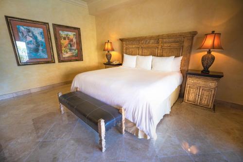 a bedroom with a large white bed and two lamps at La Mision Loreto in Loreto