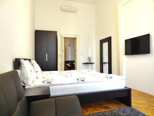 布達佩斯的住宿－埃爾茨賽貝特大道公寓，卧室配有一张白色的大床和一张沙发。