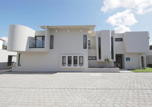 a large white house with a cobblestone driveway at Cedrela in Comayagua