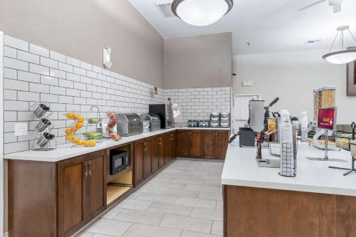 a large kitchen with wooden cabinets and white tiles at Best Western Plus Executive Inn & Suites in Manteca
