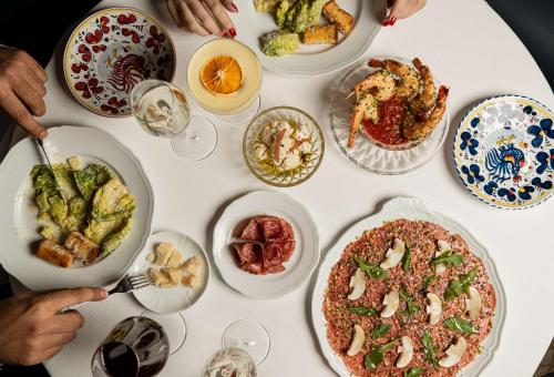 a white table with many plates of food on it at Mansard Riyadh, a Radisson Collection Hotel in Riyadh