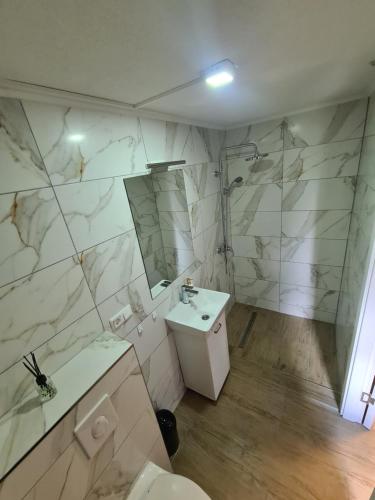 a bathroom with a sink and a toilet and a mirror at No name in Jajce
