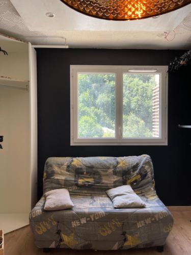 - un canapé dans une pièce avec fenêtre dans l'établissement appartement idéalement situé, à La Trinité