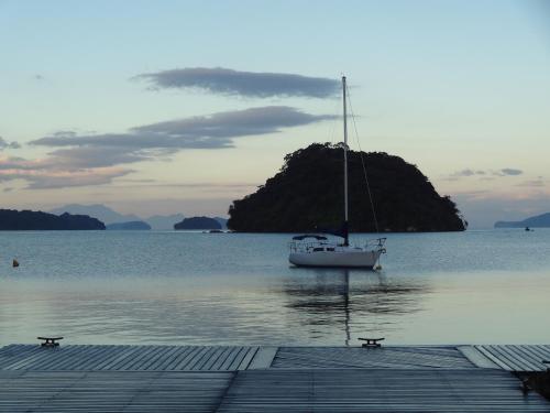 a boat sitting on the water near a dock at Casa Estrela do Mar in Angra dos Reis