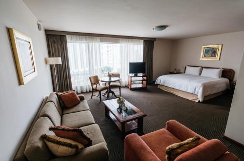 a hotel room with a bed and a couch at LUOXO Hotel in Lima