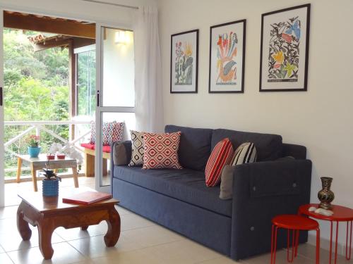 a living room with a blue couch and a table at Casa Estrela do Mar in Angra dos Reis