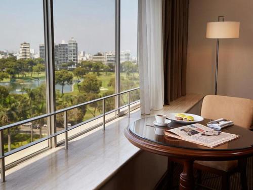 una camera d'albergo con tavolo e ampia finestra di BTH Hotel Lima Golf a Lima