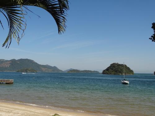 a sail boat in the water on a beach at Casa Estrela do Mar in Angra dos Reis