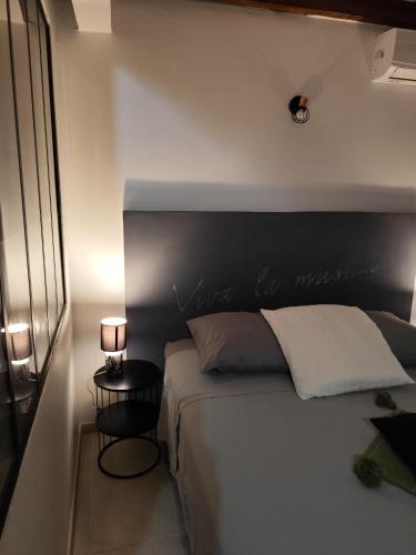 a bedroom with a white bed with a black headboard at BE BLUE GREEN in Fort-de-France