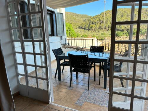 a dining room with a table and chairs on a balcony at Piso en Vall de Almonacid con vistas, aire acondicionado, Wifi y Smart TV in Vall de Almonacid