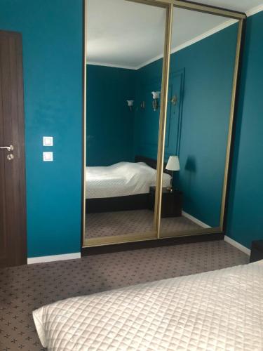 a mirror in a blue room with a bed at Stara Praga in Warsaw