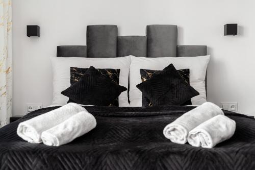 a bed with two towels and pillows on it at Gold Room in Szczecin