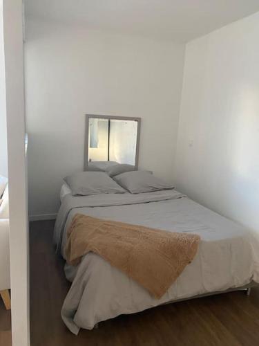 - une chambre avec un lit et un miroir dans l'établissement Studio proche Paris, à Rosny-sous-Bois