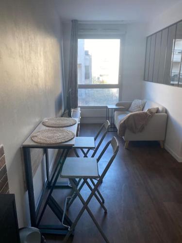un salon avec une table, des chaises et un canapé dans l'établissement Studio proche Paris, à Rosny-sous-Bois