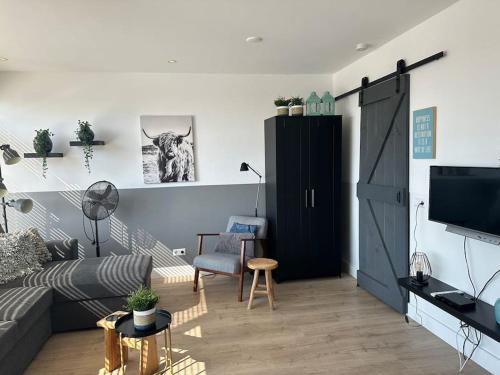 a living room with a couch and a tv at De schelp 71, Free parking in Zandvoort