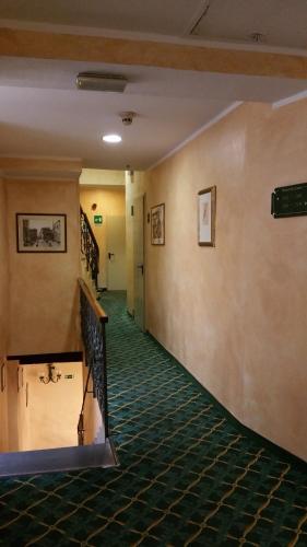 a hallway of a building with a staircase and green carpet at Hotel De Lanzi in Florence