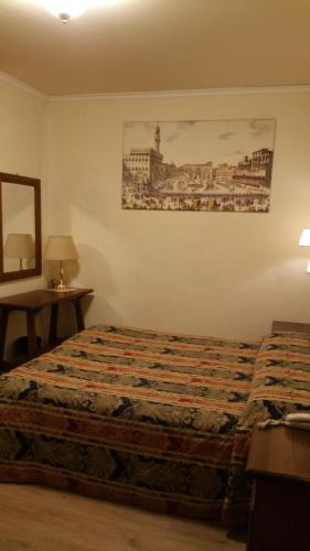 a bedroom with a bed and a picture on the wall at Hotel De Lanzi in Florence