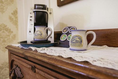 two coffee mugs sitting on top of a wooden dresser at Weaverville Hotel in Weaverville
