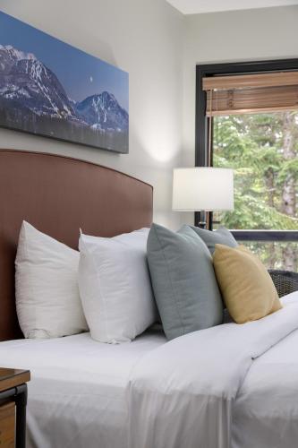 a bedroom with a bed with white pillows and a window at Spacious 3BR Condo in Whistler in Whistler