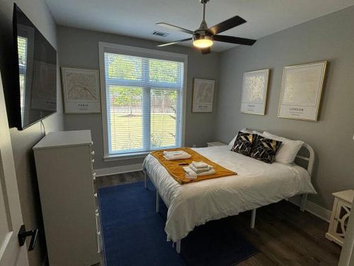 Schlafzimmer mit einem Bett, einem Ventilator und einem Fenster in der Unterkunft Gated Hideaway in Greenville in Greenville