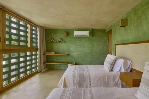 a bedroom with two beds and green walls at Punta Nayaá - Adults Only in Puerto Escondido