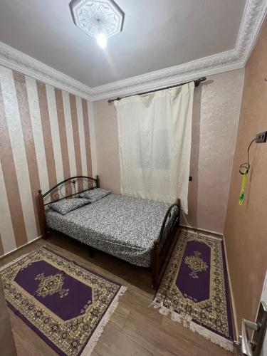 une chambre avec deux lits et deux tapis dans l'établissement Maison montagne à Aqesri, à Annsri