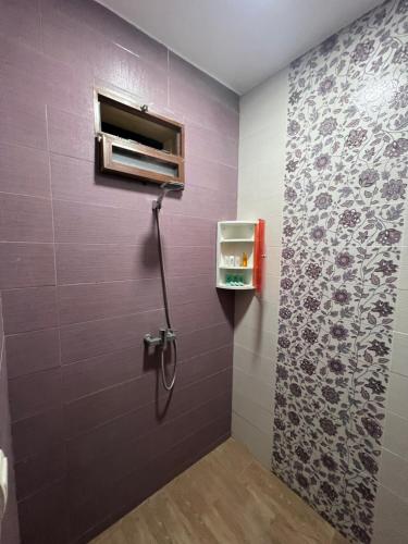 une douche dans une salle de bain avec un mur violet dans l'établissement Maison montagne à Aqesri, à Annsri