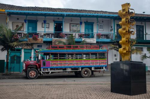 a colorful bus parked in front of a building at Hotel El Tesoro Sonson in Sonsón
