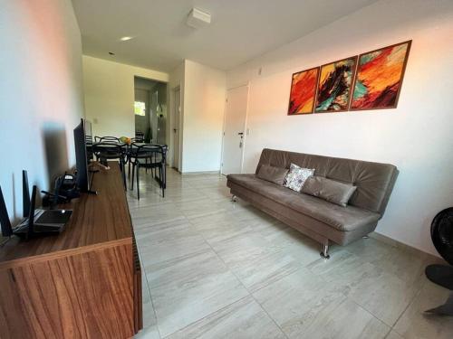 a living room with a couch and a dining table at Condomínio Ecoville das Mangueiras Região de Praia de Guarajuba in Camacari