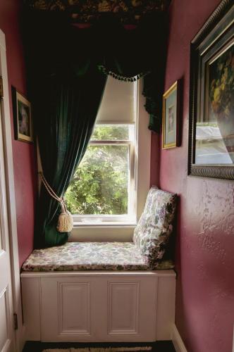 a window seat in a pink room with a curtain at Weaverville Hotel in Weaverville